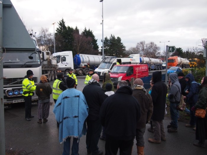 A hotly contested source of energy: Trucks, police and protestors gathering at the entrance to the private road, also a public footpath, where the Barton Moss exploration site was situated. The protestors have staged daily protests, Monday – Friday, by walking in front of lorries and vehicles entering and leaving the site. Vehicles would arrive in convoy. Photo taken January 2014 by Craig Thomas.